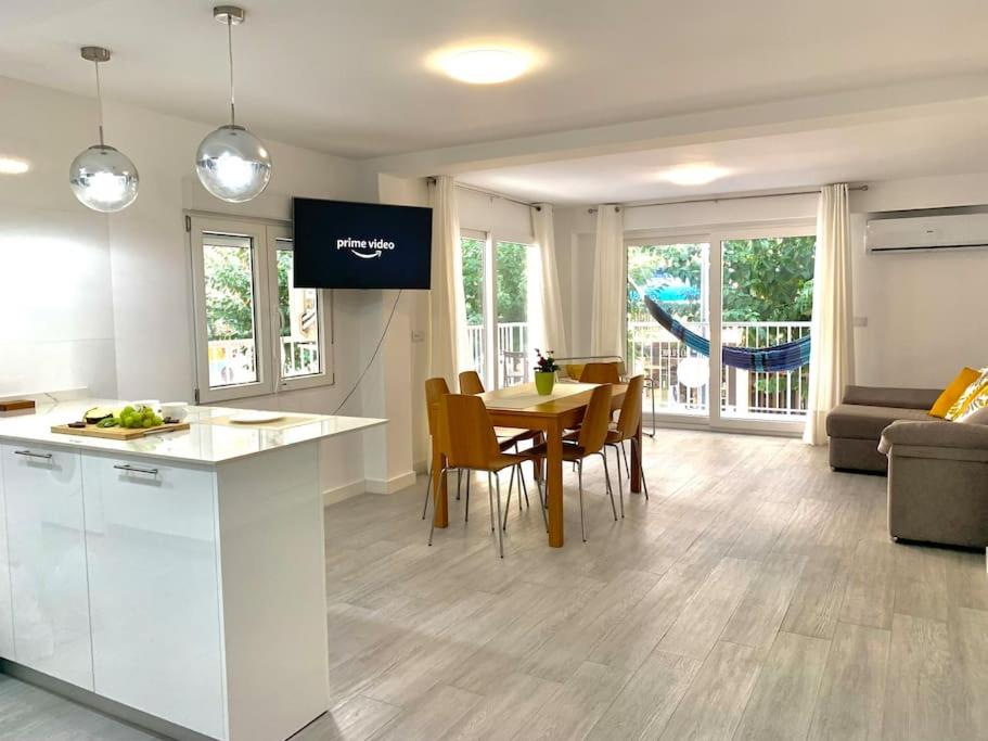 eine Küche und ein Wohnzimmer mit Tisch und Stühlen in der Unterkunft NEW STYLISH BEACH FRONT APARTMENT in Cullera