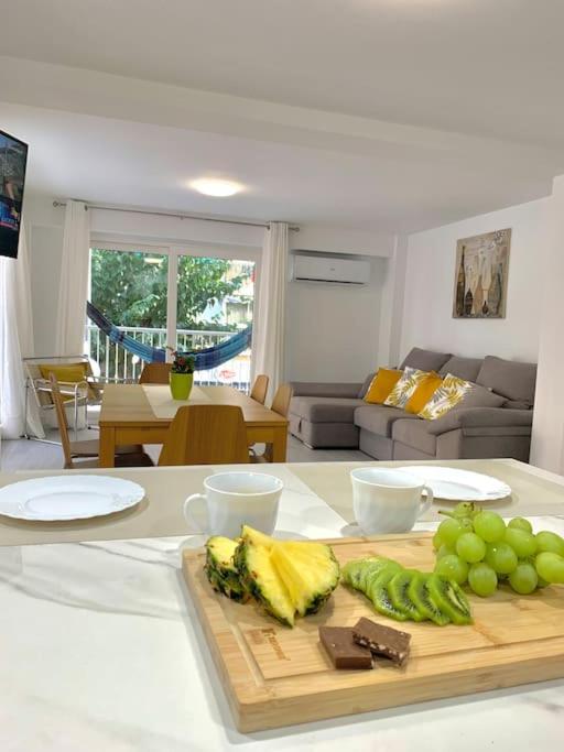 a kitchen counter with a cutting board with green grapes at NEW STYLISH BEACH FRONT APARTMENT in Cullera