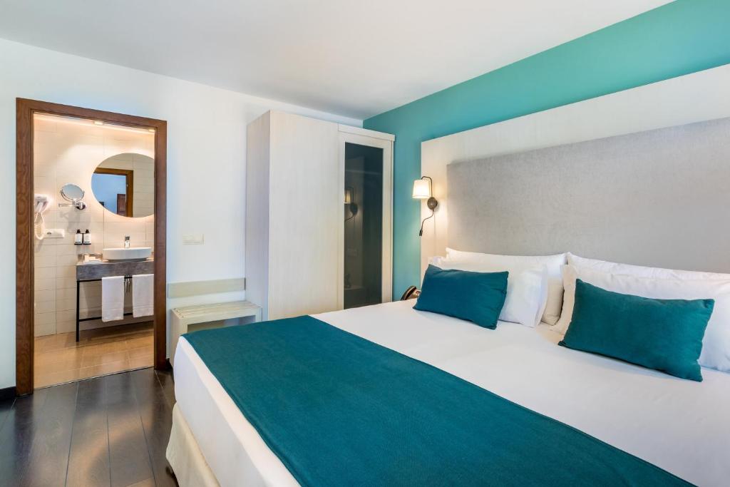 A bed or beds in a room at Occidental Pueblo Acantilado