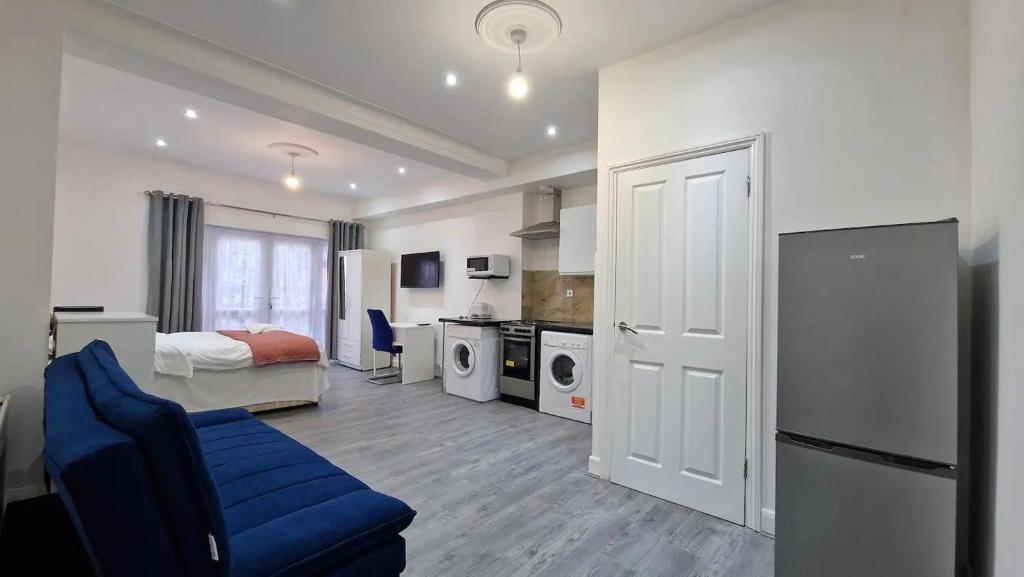 Impeccable 1-Bed Apartment in Ilford في إلفورد: غرفة نوم بسرير واريكة زرقاء في غرفة