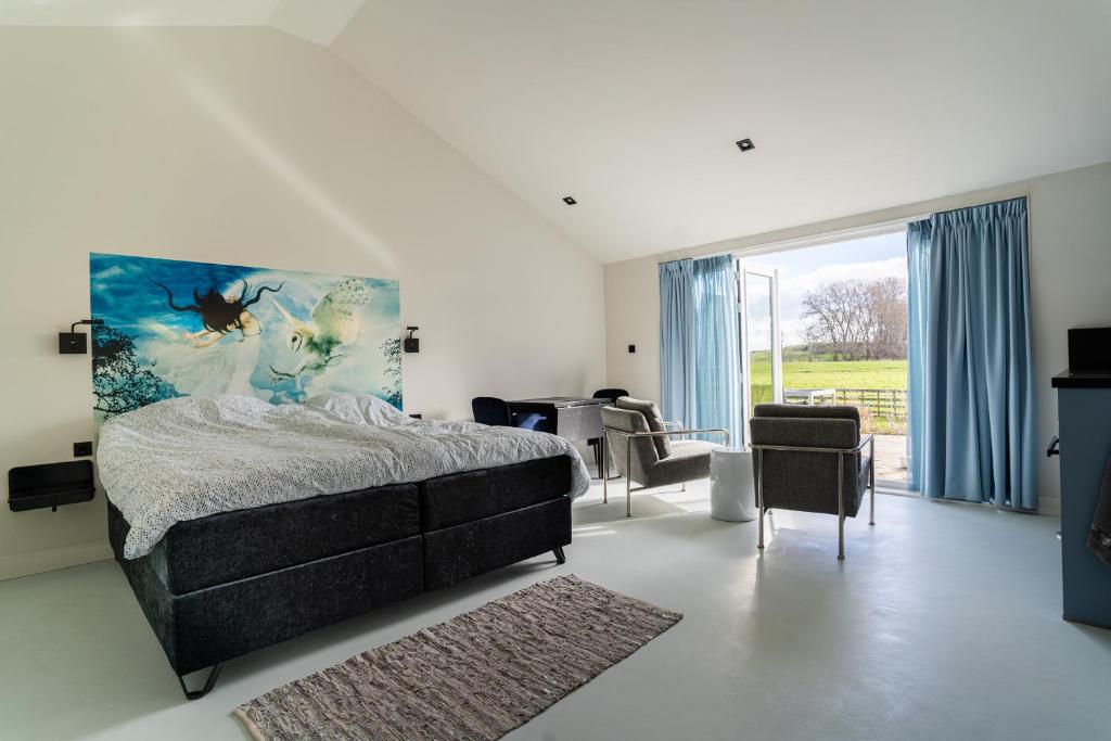 a bedroom with a bed and a large window at Huize Leeghwater in Zuidoostbeemster