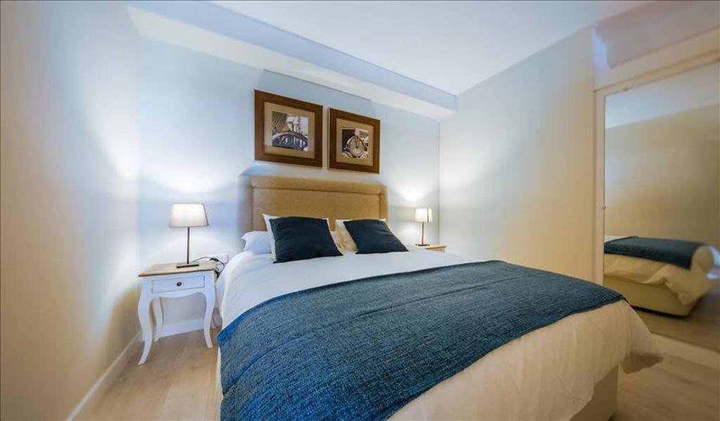 1 dormitorio con 1 cama grande y espejo en Colon Suites en Madrid