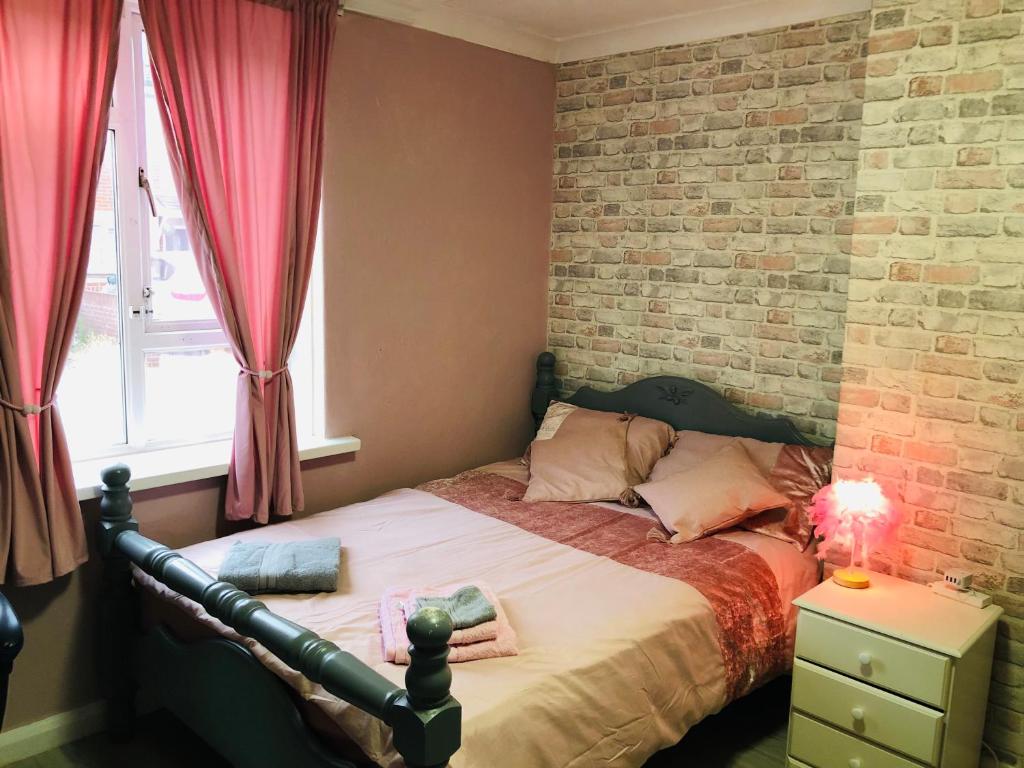 a bedroom with a bed with a brick wall at Three bed city centre flat in Portsmouth