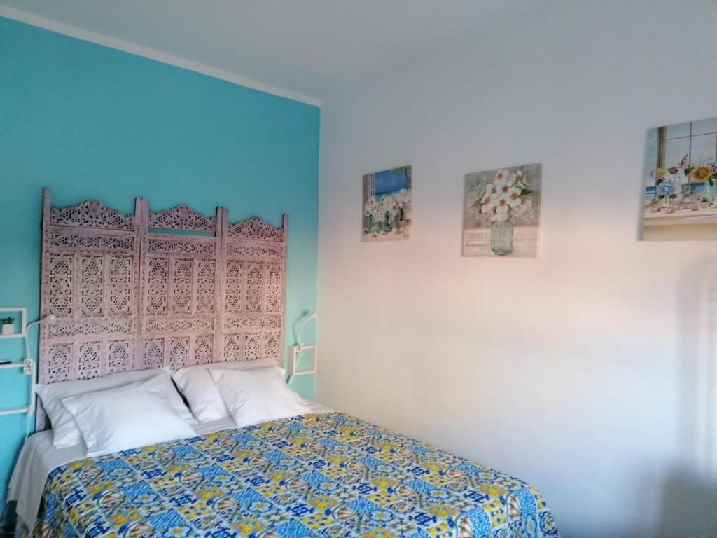 una camera con un letto e due quadri appesi al muro di Casa Giusitta a Catania