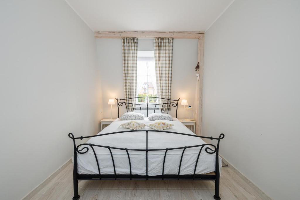 sypialnia z czarnym łóżkiem z białą pościelą w obiekcie Apartament Prowansalski w Rewalu