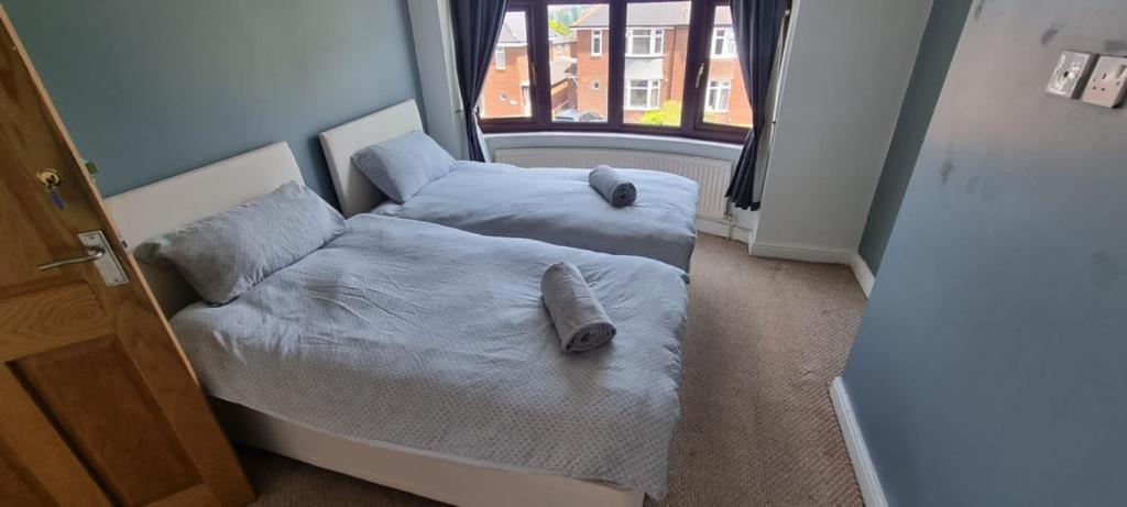 two beds with pillows in a room with a window at Thorpe House Suites in Heeley