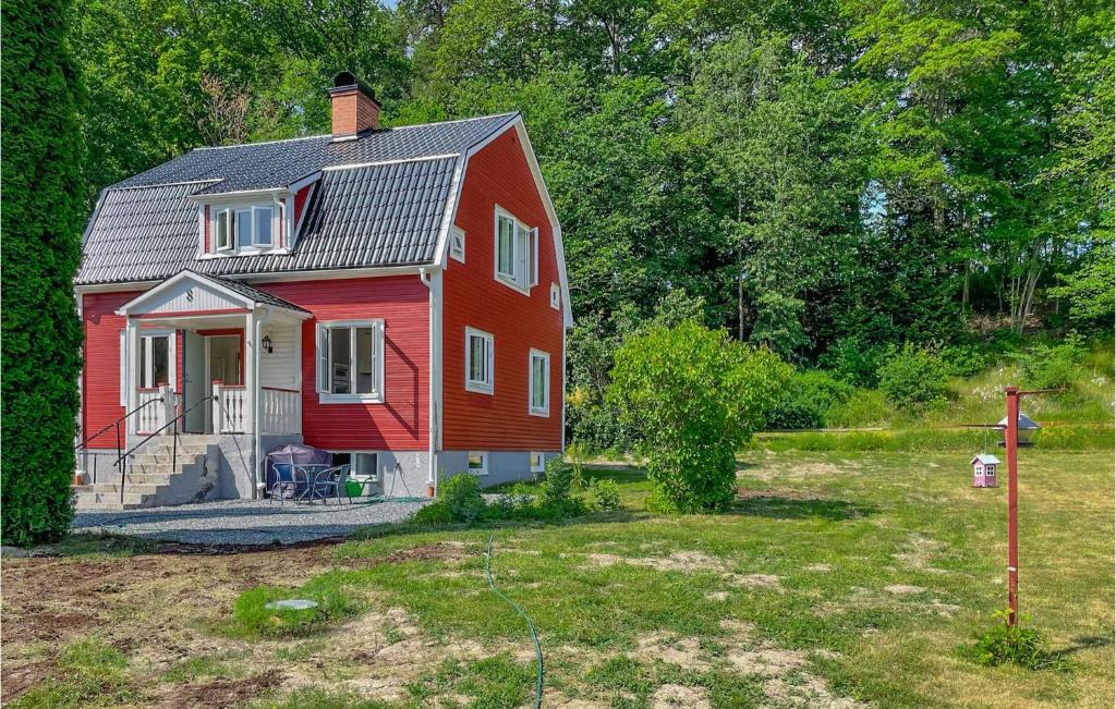 una casa roja sentada en un patio junto a un campo en Nice Home In Edsbruk With Kitchen en Edsbruk