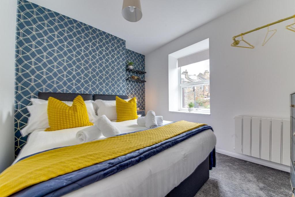 a bedroom with a large bed with yellow and blue at Exquisite flat in Sheffield in Sheffield