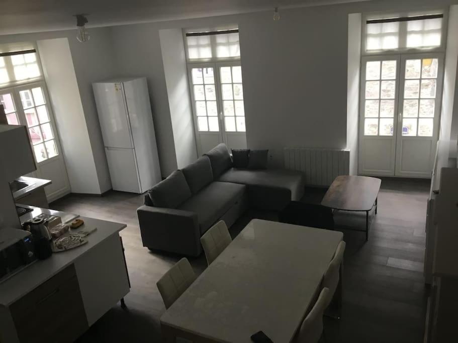 uma sala de estar com um sofá e uma mesa em Bel appartement dans petite citée de caractère em Tréguier