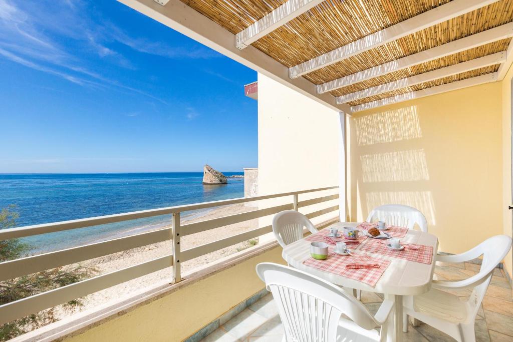 una mesa blanca y sillas en un balcón con vistas al océano en Vento d`estate by BarbarHouse, en Torre Pali