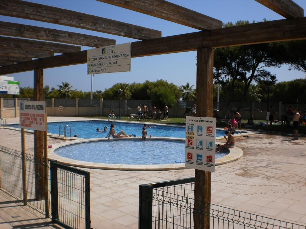 a swimming pool with people in the water at Apartamentos Alcocebre Suites 3000 in Alcossebre