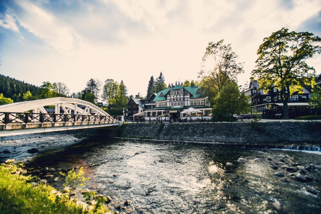 a bridge over a river in front of a house at Depandance Villa Hubertus in Špindlerův Mlýn