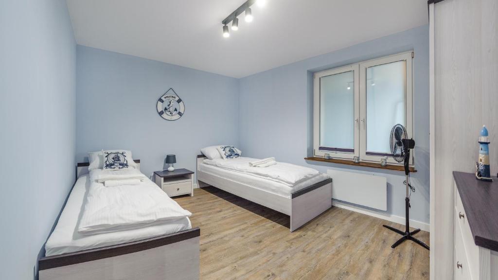 a room with two beds and a window at Apartamenty Sun & Snow Helski Zakątek in Hel