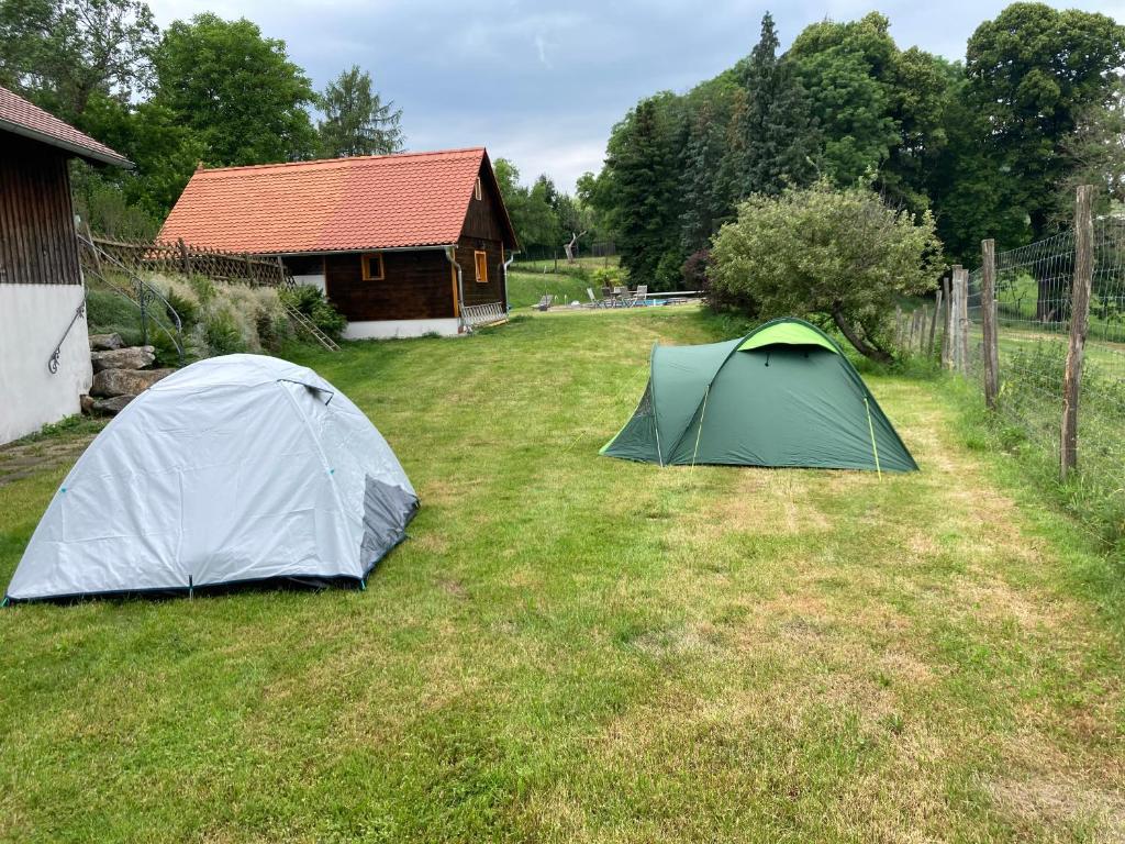 two tents in the grass in front of a house at Camping f Selbstversorger Gut Jägerhof in Semriach
