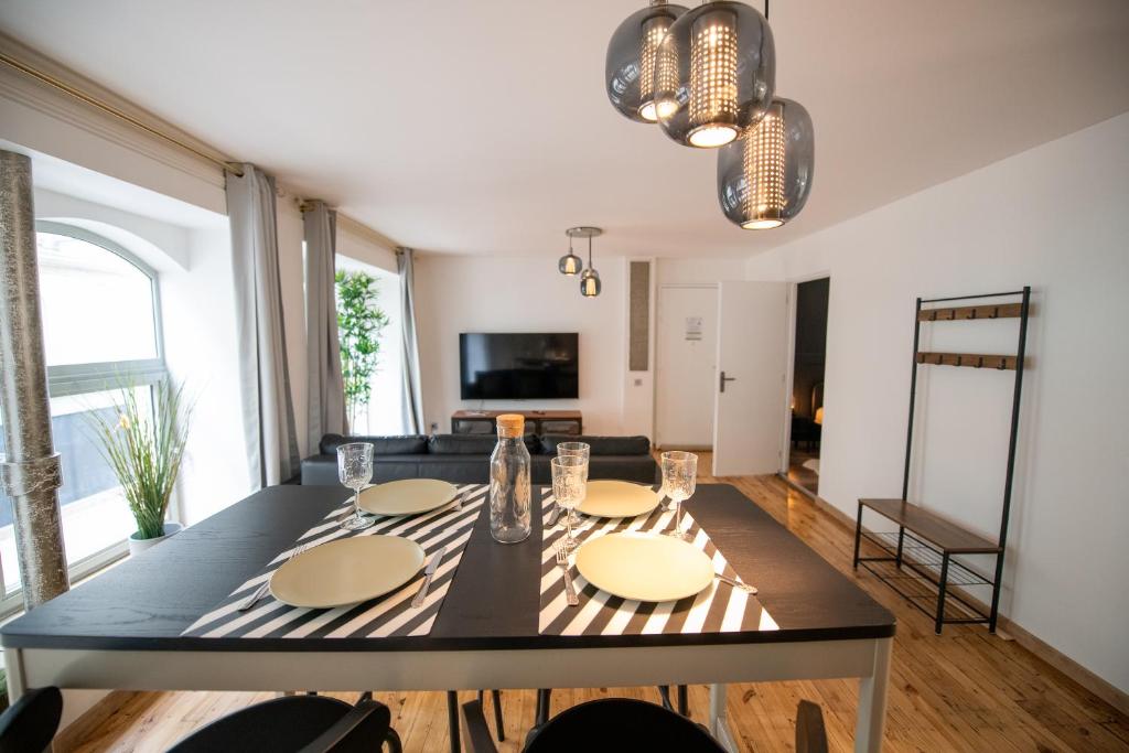 een eetkamer met een tafel en een woonkamer bij LA FABRIQUE - Centre ville - Climatisation in Saint-Étienne