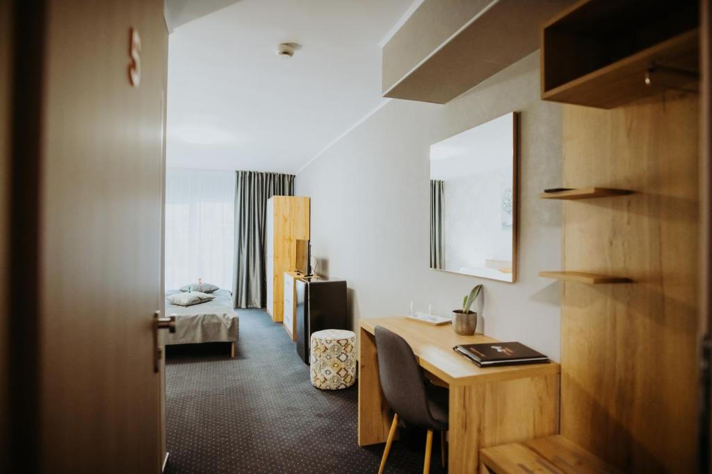a room with a desk and a room with a bed at Hotel Epic Centrum in Cisnădie