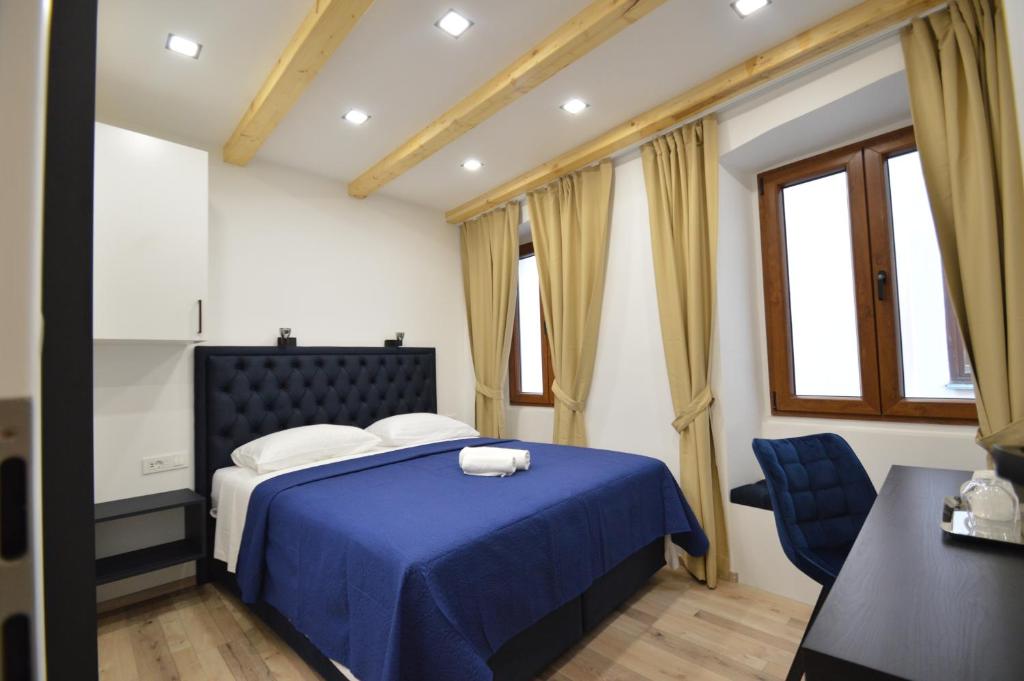 een slaapkamer met een blauw bed en een blauwe stoel bij K rooms old town self check in in Zadar