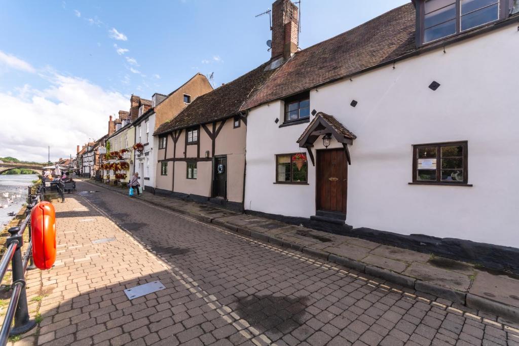 a cobblestone street in a town with white buildings at Bewdley River Cottage - Free private gated parking for 2 cars - River front location in Bewdley