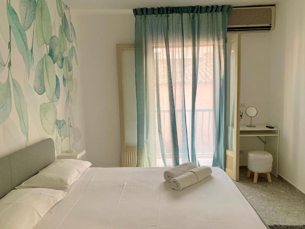 - une chambre avec un grand lit blanc et une fenêtre dans l'établissement Casa vacanza La Cuphea, à Marina di Ragusa