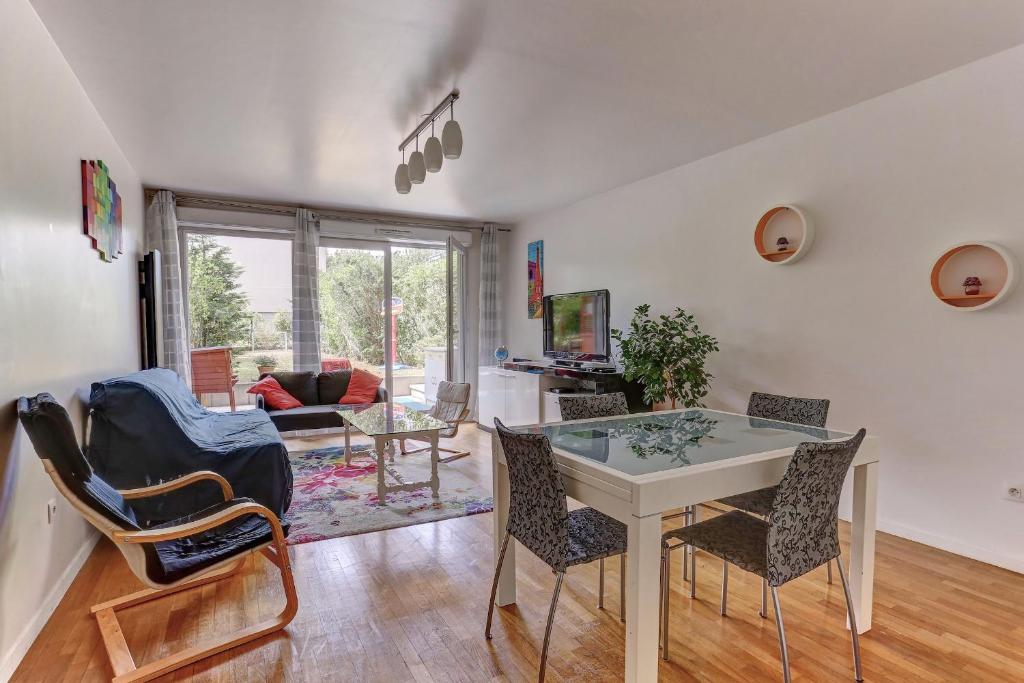 un salon avec une table et des chaises dans l'établissement Le Montespan- Saint Cyr, à Saint-Cyr-lʼÉcole