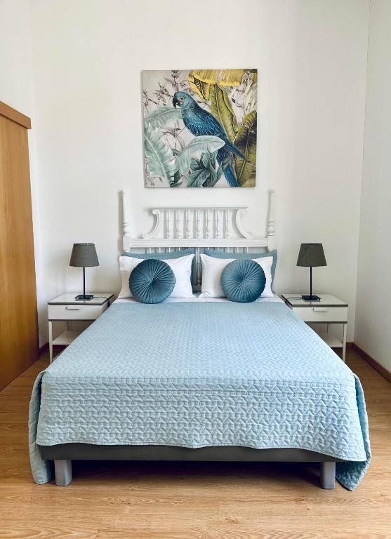a bedroom with a blue bed with two night stands at Guest house D. Filipe I in Porto