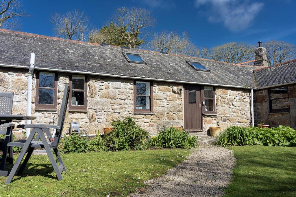 une ancienne maison en pierre avec une pelouse devant elle dans l'établissement Idyllic Cornish cottage in the beautiful Lamorna valley - walk to pub & sea, à Paul