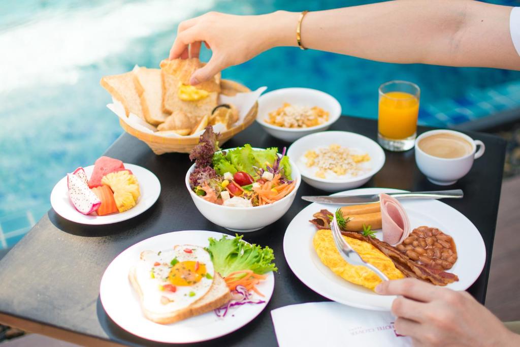 a table with plates of food on a table at Hotel Clover Asoke - SHA Extra Plus in Bangkok