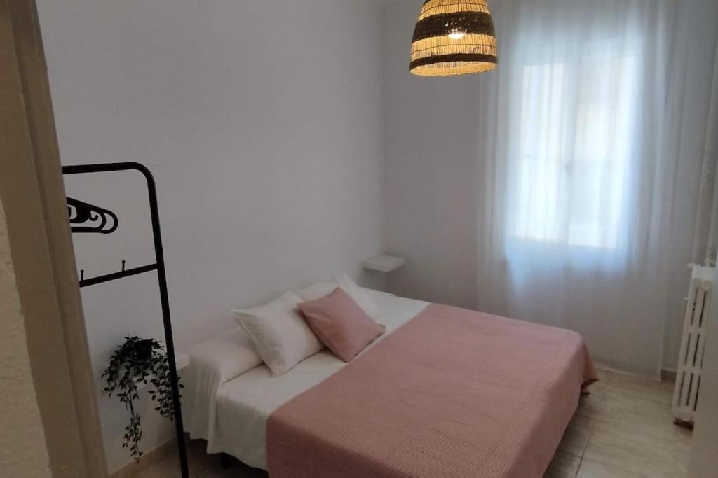 ein kleines Schlafzimmer mit einem Bett und einer Lampe in der Unterkunft Apartamento al lado del Museo DalÍ in Figueres