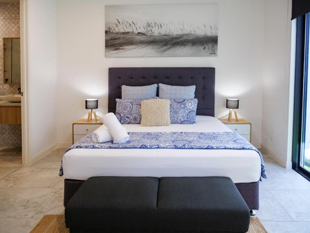 1 dormitorio con 1 cama grande con almohadas azules en Karma Villas en Gold Coast