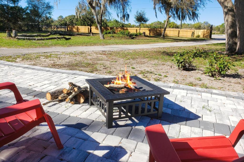 a fire pit in a patio with two red chairs at Country Quiet in Sanford