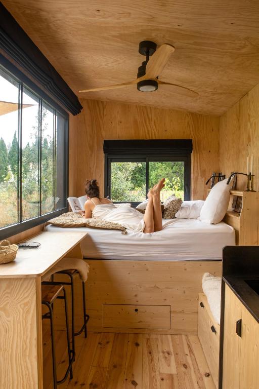 deux femmes allongées sur un lit dans une petite maison dans l'établissement Pépiite Terre de Provence - Lodge nature & spa, à Châteaurenard