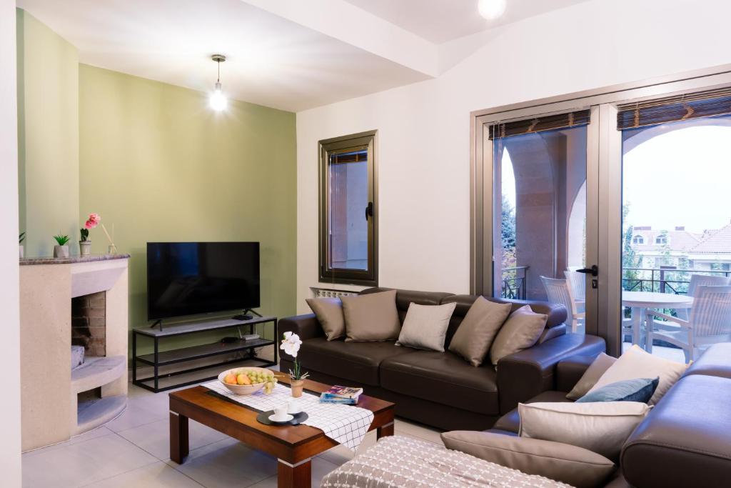 ein Wohnzimmer mit einem Sofa und einem TV in der Unterkunft hotelise I Paradise Apartment in Yerevan