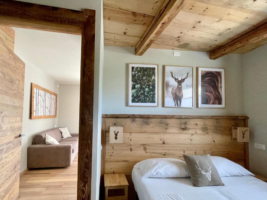 a bedroom with a bed and a couch in a room at La Maison - Il Riparo del Cervo in Bardonecchia