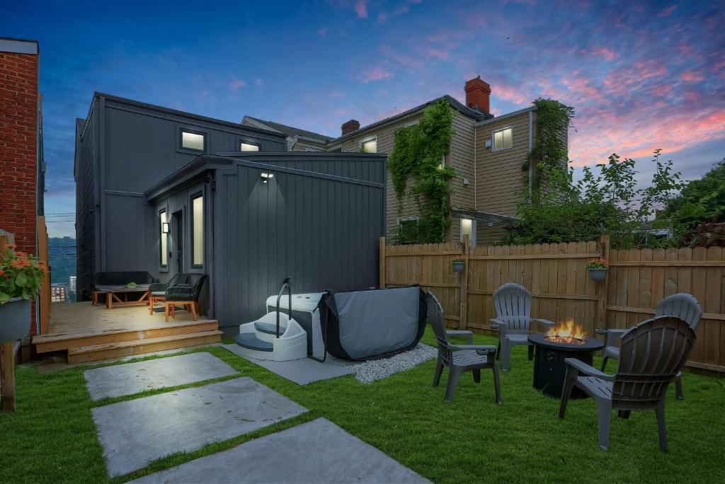 a small backyard with chairs and a house at Urban Oasis Retreat With Luxury Design, Hot Tub, Fire Pit, Breathtaking Downtown & River Views in Pittsburgh