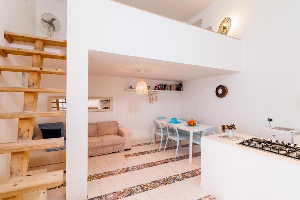 cocina y sala de estar con mesa y sofá en Appartamento Tevere, en Castrignano del Capo