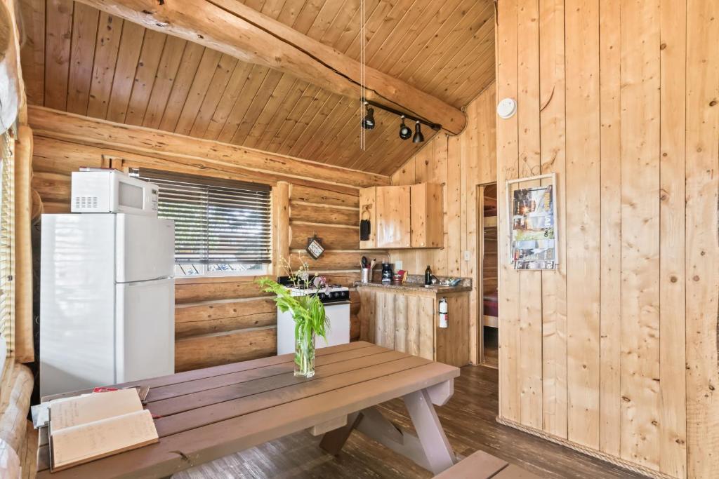 uma cozinha com um frigorífico branco e uma parede de madeira em Coho Salmon em Soldotna
