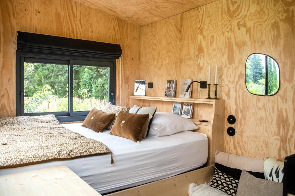 - une chambre avec un grand lit et une fenêtre dans l'établissement L'Atelier Tiny House Provence, à Châteaurenard