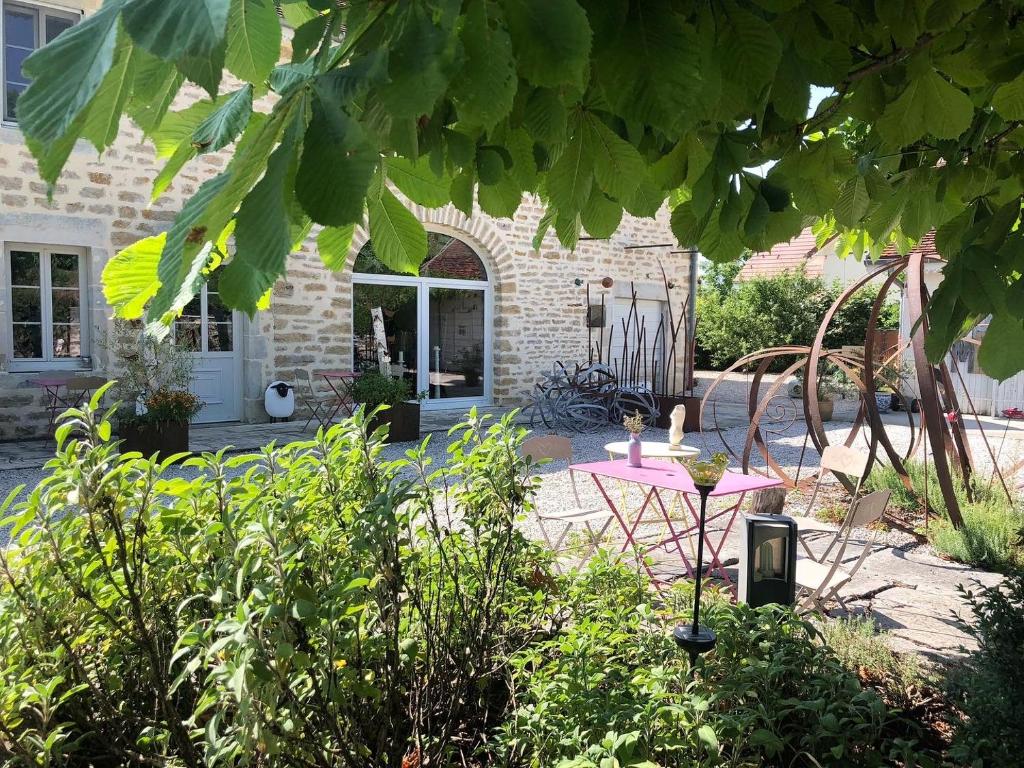 una mesa rosa frente a una casa de ladrillo en L'Entre-Coeur, en Ménétru-le-Vignoble