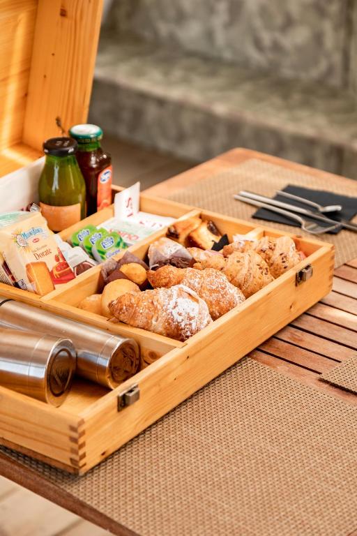 a wooden tray filled with different types of food on a table at Nabi Resort Glamping & SPA in Castel Volturno