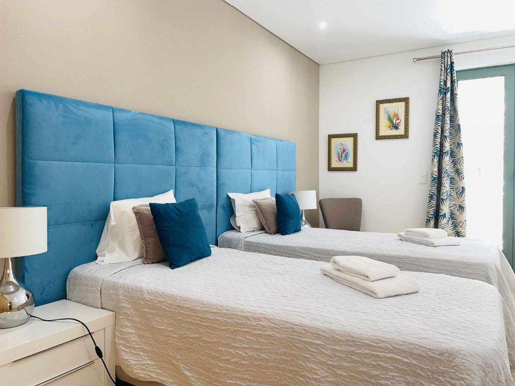 - 2 lits avec des têtes de lit bleues dans une chambre dans l'établissement Marina Vilamoura Aquamar 009 By Vilamoura Sun, à Loulé