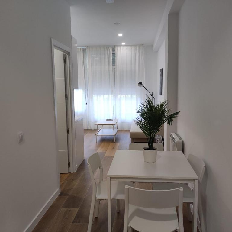 un comedor blanco con mesa y sillas en Garcia Noblejas Apartments, en Madrid