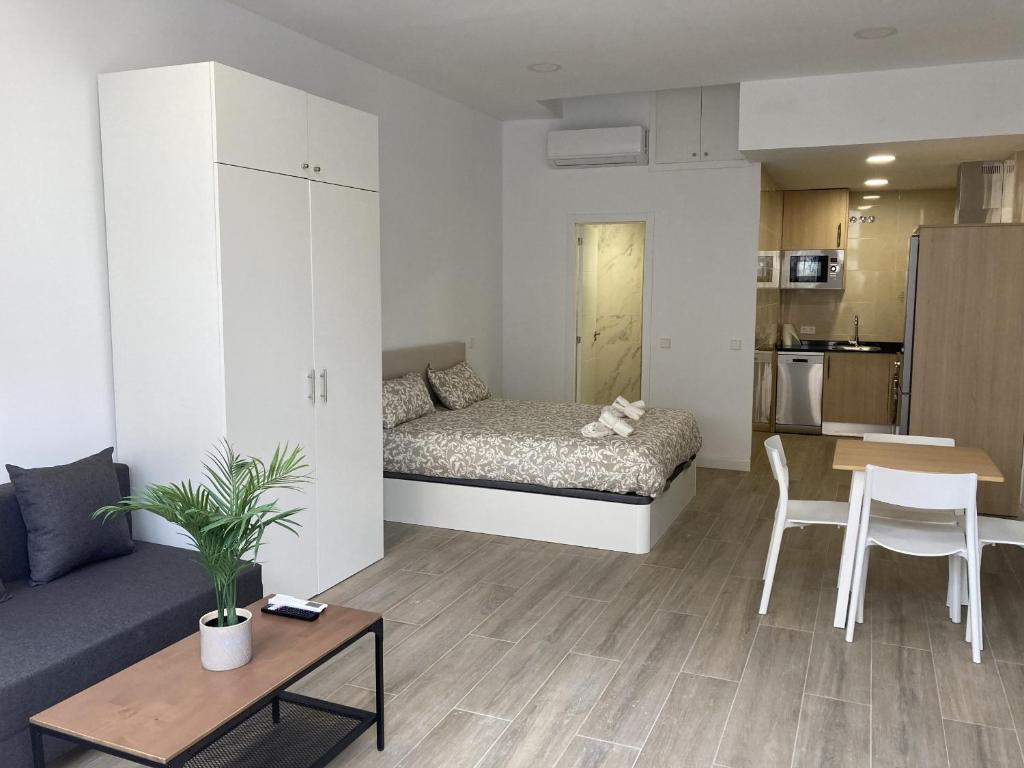 una pequeña sala de estar con cama y mesa. en San Sebastián Apartments, en San Sebastián de los Reyes