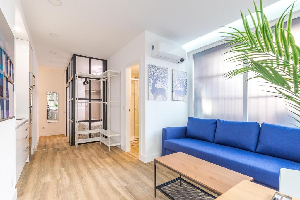 馬德里的住宿－Arturo Soria Apartments2，客厅配有蓝色的沙发和桌子