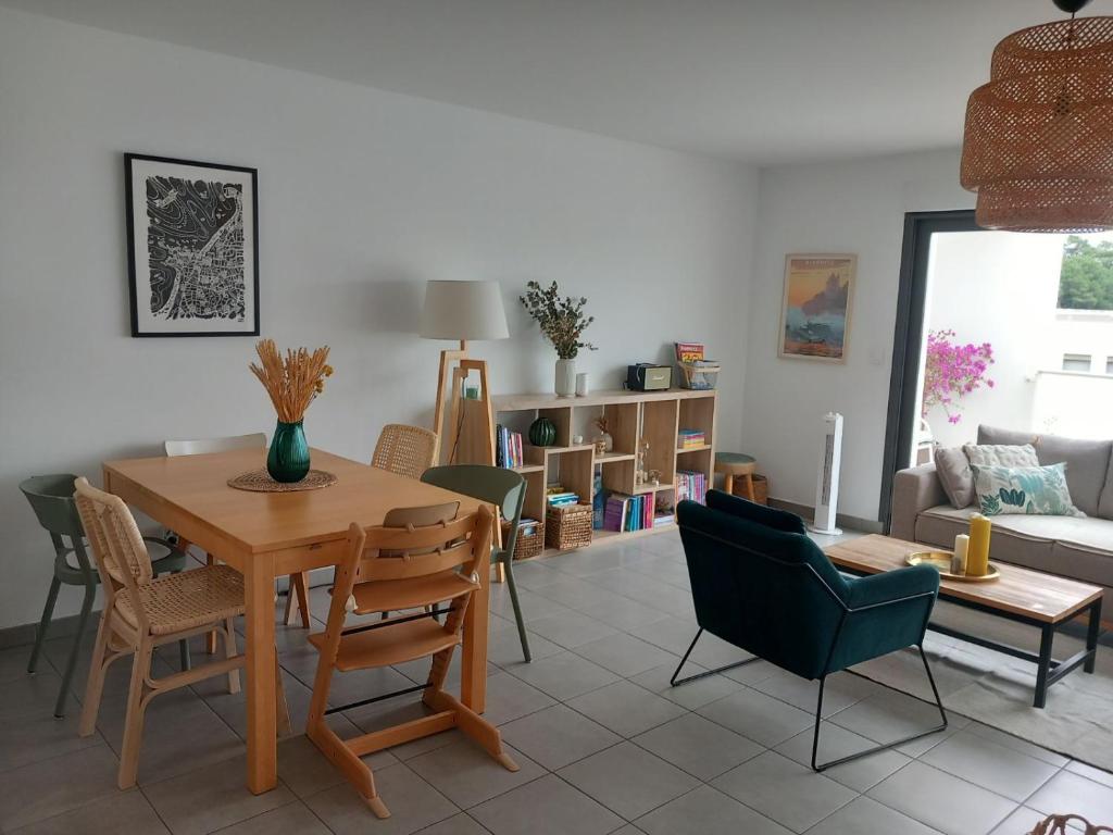un salon avec une table et des chaises en bois dans l'établissement Superbe appartement en résidence proche du centre, à Biarritz
