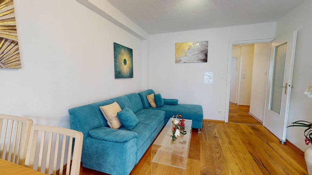 ein Wohnzimmer mit einem blauen Sofa und einem Tisch in der Unterkunft Petite France with 1 free parking in Straßburg