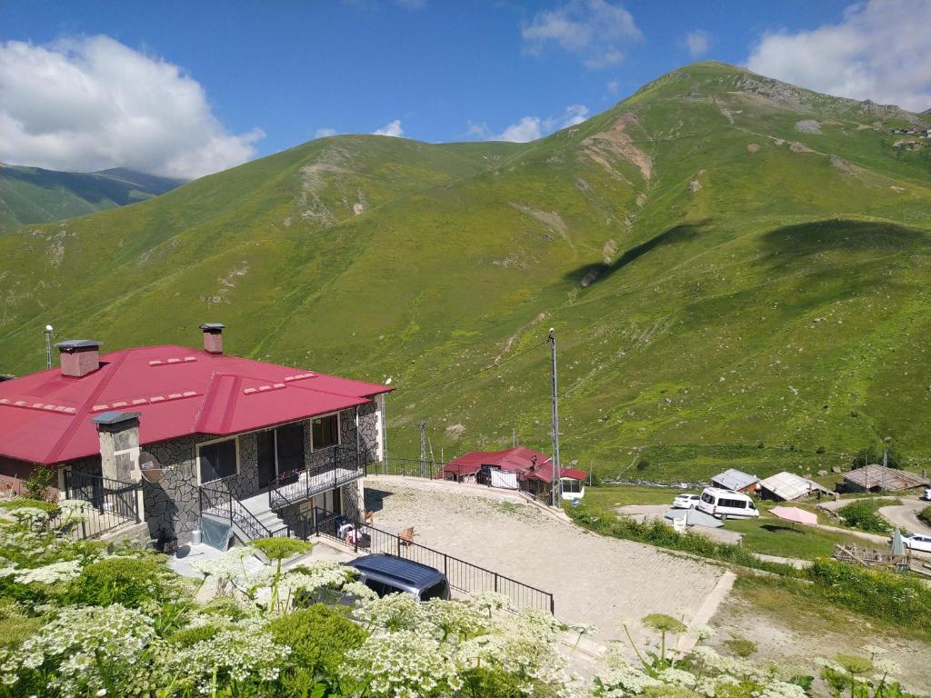 ein Gebäude mit rotem Dach vor einem Berg in der Unterkunft Şahin Apart - Demirkapı - UZUNGOL in Çaykara