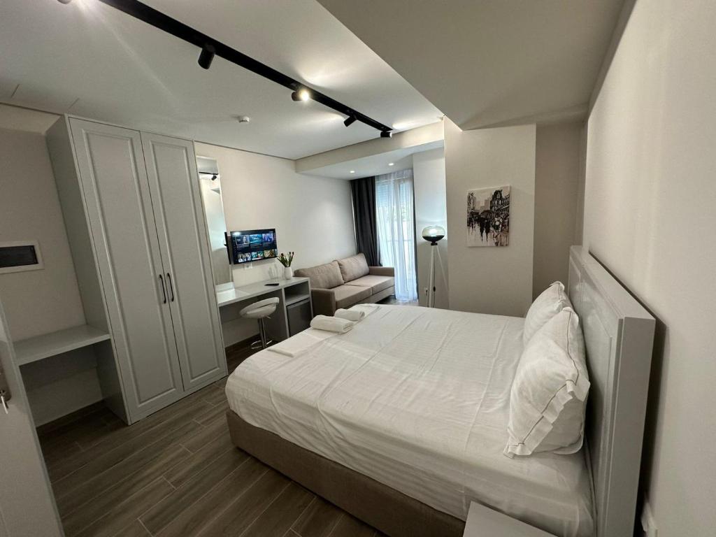 a bedroom with a bed and a desk in it at Vila Kapllani Rooms in Durrës