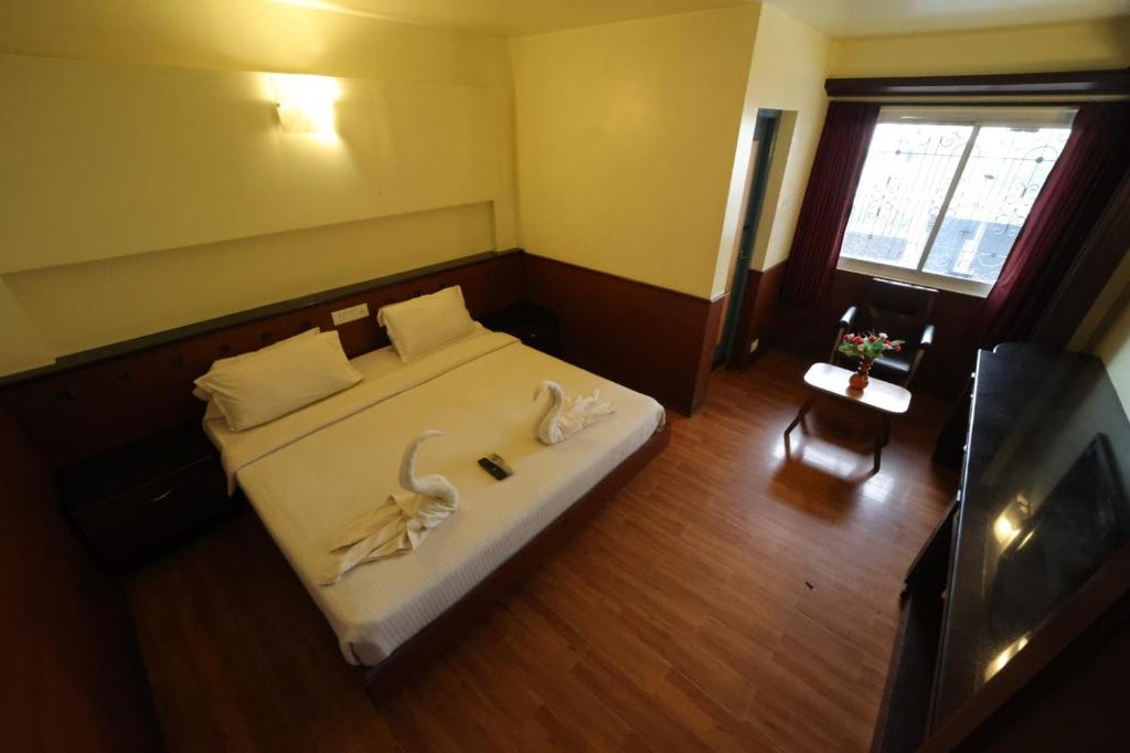 Uma cama ou camas num quarto em Jayaraj Residency