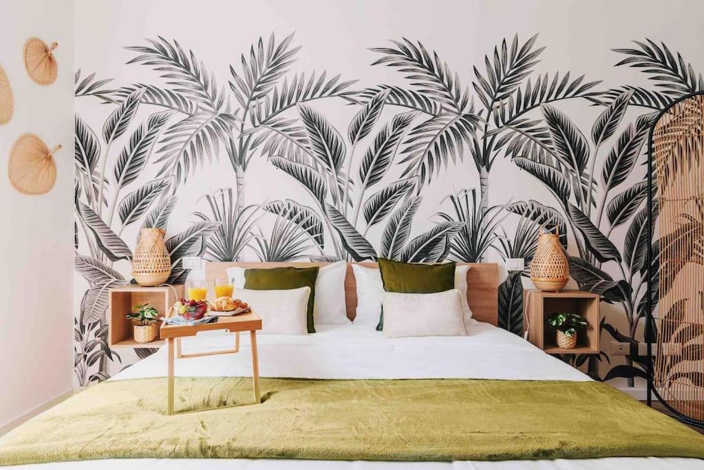 1 dormitorio con 1 cama con papel pintado de palmera en New Jungle & Charming Flat - zona De Angeli en Milán