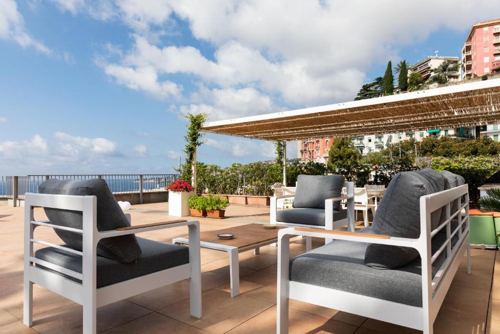 a patio with chairs and a table on a roof at MARGHERITA 109 in Naples